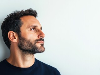 Fototapeta premium Contemplative portrait of a mature bearded man deep in thought with a serious and introspective expression highlighted by soft shadows isolated against a clean white background