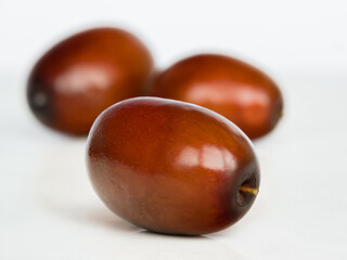 Macro shot of ripe unabi (Jiziphus jujube (jujube)) fruits on a ceramic surface