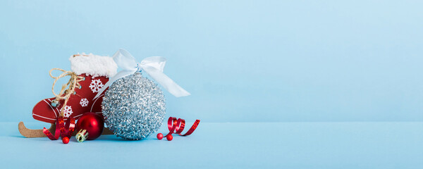 Christmas ball with skates on colored background. decoration bauble with ribbon bow with copy space