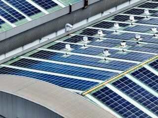 Rooftop solar panels on an industrial plant building. Clean and renewable power solutions, green...