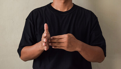 Sign Language man interpreter gesturing in sign language on gray background