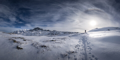 Panorama of the french Alps with the Mont Blanc and a skier in the fresh snow. Ski touring in Beaufortain