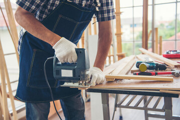 DIY craftsperson asian man working wood heap carpenter objects woodwork desk. Architect man hands use ruler measure hammer home improvement. Wooden builder carpenter repairing construction workshop