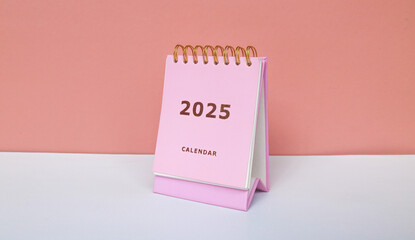 2025 calendar in pink isolated on pink background. Calendar and Note Pad Happy New year 2025. 2025 New Year resolutions goal, plan, and action concept