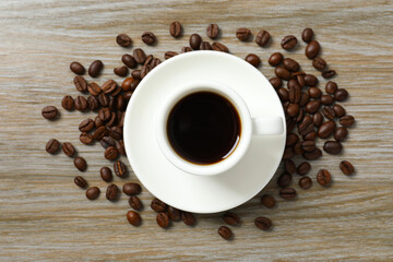 Cup of coffee and coffee beans on wooden background