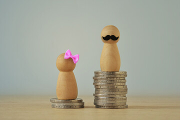 Pawn with pink hair bow and pawn with moustache on piles of coins - Gender wage gap concept