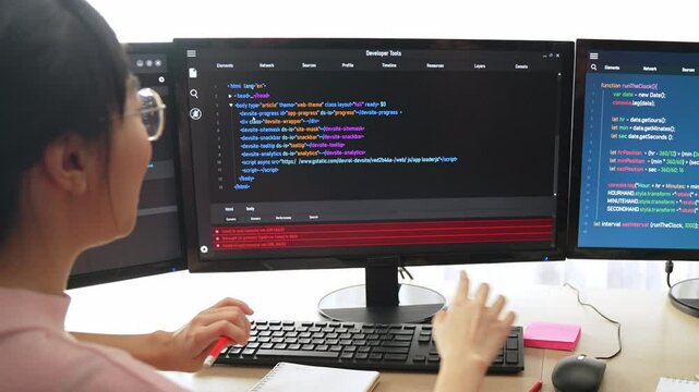 Slow motion back end software developer engineer for computer programming working together on debugging writing computing code, solving complex algorithms display on monitor in office. Burgeoning