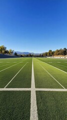 Obraz premium A clear view of a football field with marked lines and a blue sky.