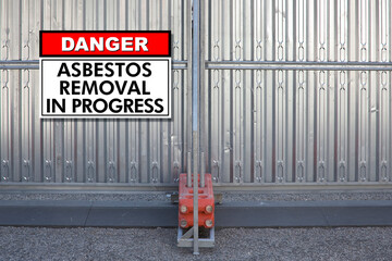 DANGER ASBESTOS REMOVAL IN PROGRESS WARNING SIGNBOARD - Concept with protection steel barrier...