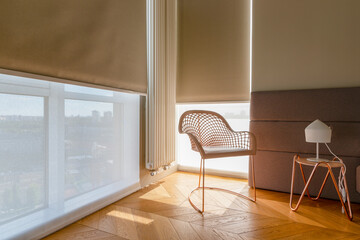 Modern automatic roller blinds and sun shades cover large windows, diffusing natural light into...