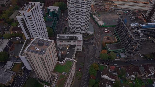 Aerial view circling above Croydon high rise apartment towers in low evening sunlight