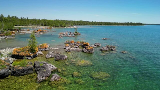 Aerial flyover lychen covered rocks along Lake Huron shoreline, Les Cheneaux Islands, Michigan
