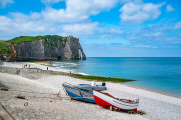 Fischerboote liegen vor den malerischen Felsen am Meer in Etretat, Normandie, Frankreich