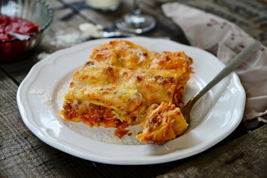 Close-up of a plate of lasagne with a forkful of food ready to eat