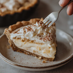 Action Shot of a Fork Slicing Through a Creamy Banoffee Pie Slice with Whipped Cream