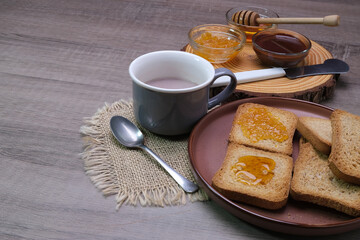 Tazza con cioccolata e fette biscottate con confettura per colazione