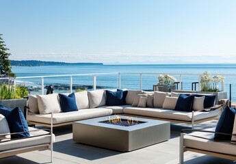 Fototapeta premium Cozy patio with beige and blue cushions, a round stone fire pit in the center of the large balcony, a white wooden fence surrounding it