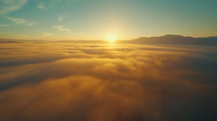A stunning aerial view of a sunrise over a sea of clouds, with the sun peeking over the horizon.