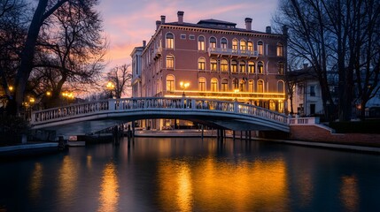 Old bridge over the canal in Venice at night, with reflections on the water