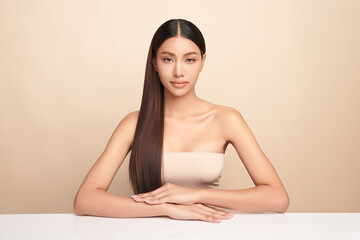Naklejka premium Beautiful young asian woman with clean fresh skin on beige background, Face care, Facial treatment, Cosmetology, beauty and spa, Asian women portrait.