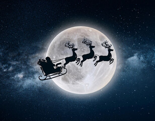 Naklejka premium Santa Claus flies his sleigh pulled by reindeer through a starry night sky with a full moon
