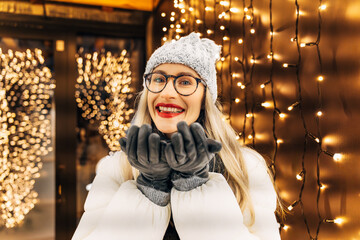 young woman in winter clothing in front of festive lights