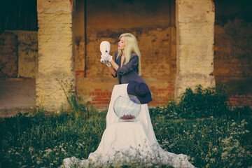 Woman holding mannequin head and feeding cherries. Concept. Fashion.