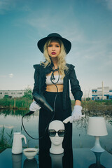 Glamorous , stylish woman cuts mannequin's head in nature. Fashion Concept, barbershop barber