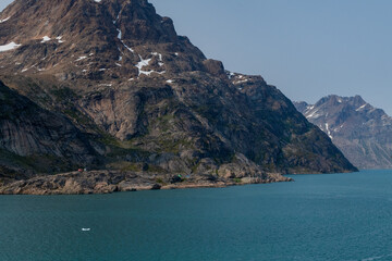 Prins Christian Sund Greenland mountain fjord with floating ice and shore iceberg on a summer day