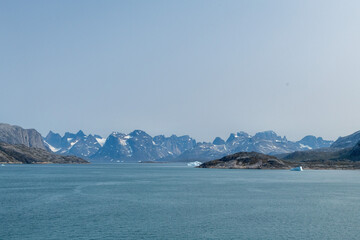 Prins Christian Sund Greenland mountain fjord with floating ice and shore iceberg on a summer day