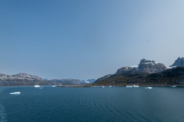 Prins Christian Sund Greenland mountain fjord with floating ice and shore iceberg on a summer day