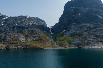 Prins Christian Sund Greenland mountain fjord with floating ice and shore iceberg on a summer day