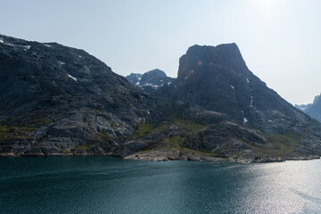 Prins Christian Sund Greenland mountain fjord with floating ice and shore iceberg on a summer day