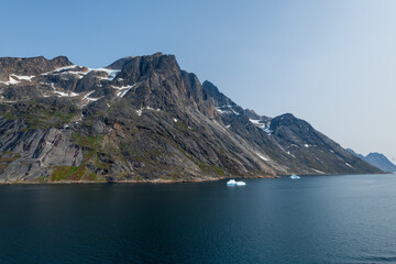 Prins Christian Sund Greenland mountain fjord with floating ice and shore iceberg on a summer day