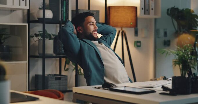 Happy man, relax and night with completion at office for productive day, job done or break by desk. Businessman, employee or working late with smile or leaning back for finished or rest at workplace