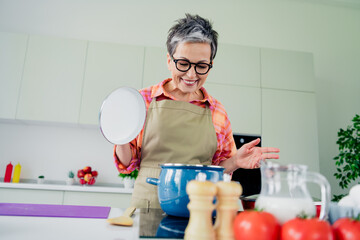 Charming senior woman enjoying her time in the kitchen preparing a delicious homemade meal with fresh ingredients and flair