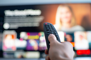 Person changing tv programs by using smart tv remote control. Close up view.