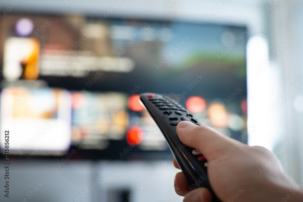 Wall mural person changing tv programs by using smart tv remote control. close up view.