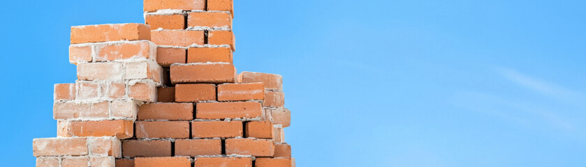 Obraz premium Building bricks stacked against clear blue sky, showcasing construction materials
