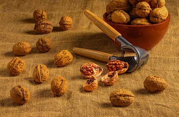 Walnuts and nutcracker on burlap.
