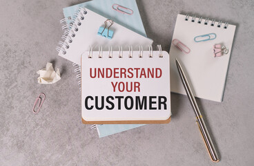 Blank sheet, pen and crumpled paper balls on grey table, flat lay. UNDERSTAND YOUR CUSTOMER