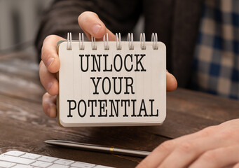 UNLOCK YOUR POTENTIAL text on white card, amid financial statements.