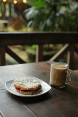 toast with cheese topping and a glass of coffee with milk on the table