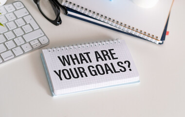Inspirational quote - Stay focused on your goals. With text message on white paper book, pen, a cup...