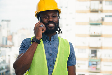 Happy African engineer man on a call in office