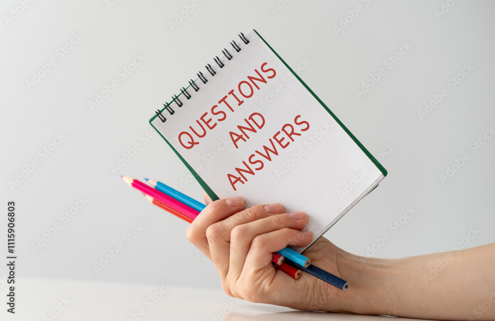 Poster questions and answers inscription on a notepad in hand on a light isolated background