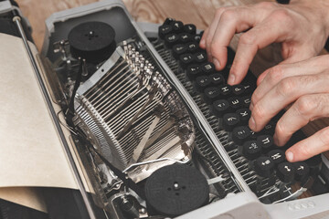 Close-up of a male hand hitting a vintage typewriter.