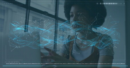 Image of financial data processing over african american businesswoman using laptop