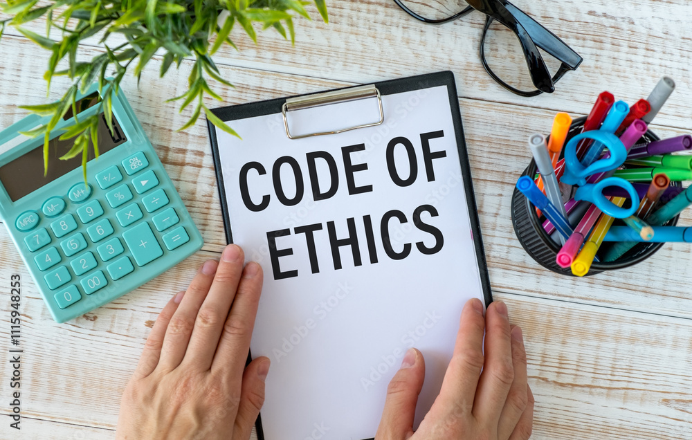 Poster code of ethics text written on notepad with pencil. notepad on a folder on wooden background.