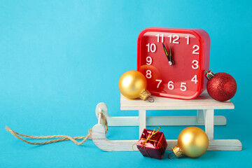 Christmas presents with a clock and sleigh on blue background, copy space